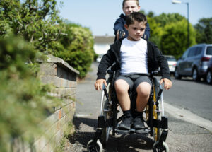 Boy pushing his brother in a wheelchair